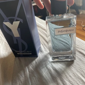 Byte Yves Saint Laurent Y Eau de Toilette - Fräsch parfym från Yves Saint Laurent, Y Eau de Toilette. Flaskan är stilren och genomskinlig med svart kork och silvrig etikett. Doften är modern och maskulin, perfekt för dig som gillar eleganta och fräscha toner. Kommer i originalförpackning ca 95 ml kvar.