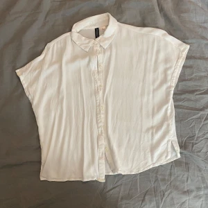 Kortärmad skjorta - Vit skjorta/blus från H&M Divided i storlek XS. Den är kortärmad med klassisk krage och knäppning framtill. Skriv om du har frågor och läs helst min bio innan du köper💫
