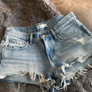 Ljusblå jeansshorts  - Snygga ljusblå jeansshorts med låg midja från Gina Tricot. De har slitna detaljer och fransig kant, säljer då dom inte passar längre tyvärr, så snyggaaa!!!