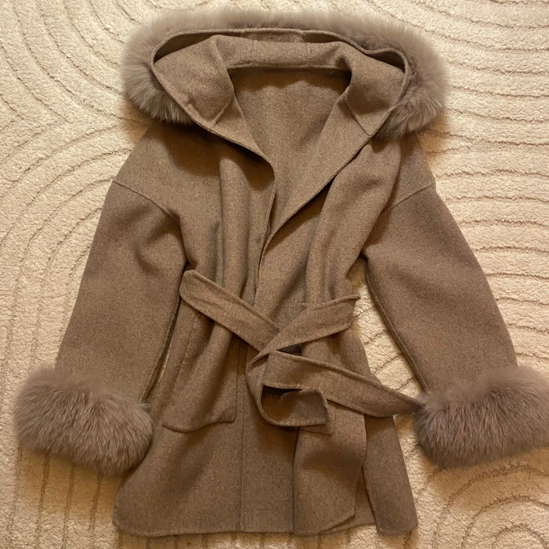 Beige kappa med pälsdetaljer och huva