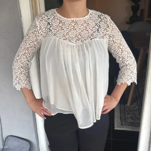 Zara Vit blus med spets och trekvartsärm - Supersöt vit blus med transparent spets upptill och på ärmarna, samt flowy chiffong nedtill. Blusen har trekvartsärmar och knäppning med små pärlknappar i nacken. Perfekt för dig som gillar romantiska detaljer och en luftig look. Strl M men passar perfekt xs/s se bild❤️