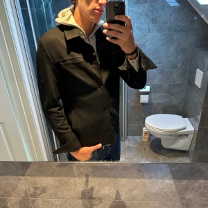 Svart overshirt från Les Deux, S - Perfekt jacka/overshirt till hösten! Denna svarta overshirt är i mycket bra skick och har inga defekter. Jag är 188cm och den är lite tight på mig. Nypris ligger på strax över 2000kr. Släng iväg ett meddelande om ni har några funderingar;)