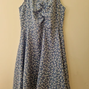 Blå blommig klänning  - Blå klänning med vita blommor. Storlek 140. Från shein. Det är lite lös tråd på framsidan men det syns inte jätte tydligt. 