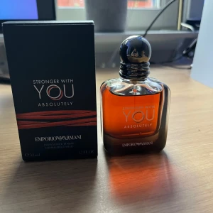 Emporio Armani Stronger With You - Emporio Armani Stronger With You Absolutely EdP, 50 ml. Flaskan är elegant med rundade former och mörk bärnstensfärgad vätska, samt en svart, glansig kork. Kommer med originalkartong i svart med röda detaljer. En modern och lyxig herrdoft. Knappast använd o passar perfekt nu inför hösten o vintern!