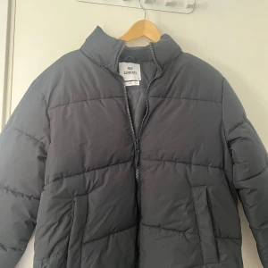 Svart pufferjacka från lager 157 - Säljer en svart pufferjacka från lager 157 i storlek S. ,två sidofickor och dragkedja framtill. Perfekt för kalla dagar med sin tjocka och quiltade design. Enkel och stilren look som funkar till många outfits.