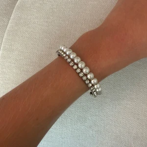 Pärlarmband med stenar  - Ett elegant armband med pärlor och stenar. Perfekt för att addera en touch av glamour till din outfit. Armbandet är elastiskt och passar de flesta handleder. Obs fattas 1 sten så säljer ut för 39kr.