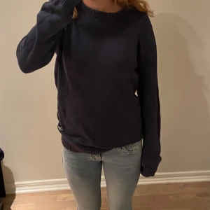 Mörkblå stickad tröja - Säljer en mörkblå stickad tröja från Dobber i storlek small. Tröjan har rund hals, ribbade muddar vid ärmslut och nederkant samt långärmad passform💕