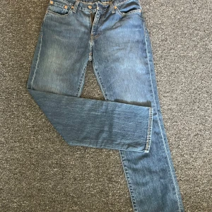 Levi's 511 blå jeans W29 L30 - Säljer ett par klassiska Levi's 511 jeans i blå denim som ej är använda någon gång. Modellen har en slim passform med raka ben och fem fickor. Snygga kontrastsömmar och Levi's ikoniska läderpatch baktill. Perfekt för dig som gillar en tidlös och clean look. 