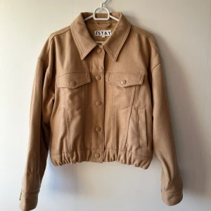 Ljusbrun jacka från Stay, stl S - Snygg ljusbrun jacka från Stay i storlek S. Jackan har klassisk krage, knappar framtill och två bröstfickor med lock. Perfekt nu till hösten.