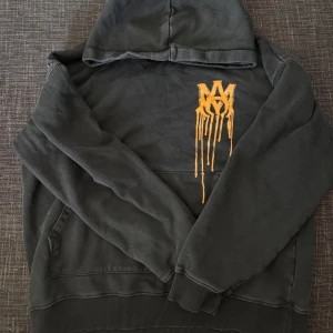 AMIRI hoodie - Säljer en svart hoodie från AMIRI med fett orange drip-tryck både fram och bak. Säljer den här tröjan då den har blivit för liten på mig. Den har förlorat lite av sin färg men inget som man har pekat ut när jag använt den. PRIS KAN DISKUTERAS!