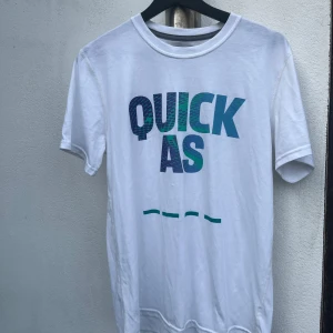 Vit Adidas t-shirt med tryck - Vanlig t-shirt från adidas i polyester o bomull med stort tryck framtill i blått o grönt, ett litet tryck av adidas loggan på ena ärmen samt en grå text i nacken. Syns att den är använd men är fortfarande i bra skick samt hel o ren. Storlek M, normal storlek o passform.