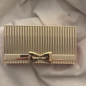 Estée Lauder Pure Color Envy ögonskuggspalett - Snygg ögonskuggspalett från Estée Lauder med 10 olika nyanser i både matta och skimrande toner. Färgerna sträcker sig från nude, beige och brunt till mörkblått och grått. Lyxig förpackning i guld med rosett och röd baksida, samt spegel inuti.