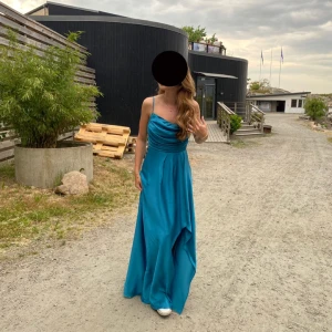 Balklänning - Säljer min balklänning i ca storlek 36. Jag är 170 och har klackar på den andra bilden. Klänningen är använd en gång och kemtvättad efter det, så den ser helt ny ut. Köpt på L&S i Göteborg. Skriv för mått! Ryggen är öppen vilket gör att den passar flera storlekar.