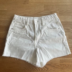 Vita jeansshorts från LAB Industries - Snygga vita jeansshorts från LAB Industries med fransig kant och klassisk femficksdesign. Justerbar midja. De har hög midja, dragkedja och knapp framtill. Tillverkade av bomull. Nästan nyskick, hela o rena. Storlek 158.