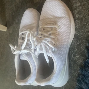 Vita mesh-sneakers strl 36 - Fräscha vita sneakers i storlek 36 med snygg mesh-ovandel och platt sula. Skorna har snörning och en sportig vibe, perfekta för dig som gillar clean och enkel stil. Lätta och bekväma med ventilerande material och rund tå.