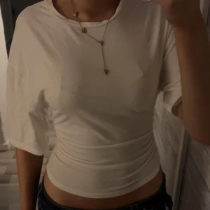 Vit croppad topp från Gina Tricot - Säljer en vit croppad topp från Gina Tricot i storlek XS. Toppen har korta ärmar och en tight passform, lös i armarna och tajt i midjan. Den har inga fläckar och använts fåtal gånger