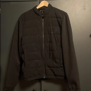 Svart pufferjacka från Zara, M men passar S också - Svart overcout/pufferjacket från Zara i storlek M. Jackan har stilren design med raka linjer, ståkrage och dragkedja framtill. Materialet är syntet och polyester, vilket gör den lätt och bekväm. Perfekt för dig som gillar minimalistisk look och vill ha en jacka som funkar till många outfits.