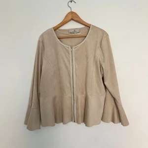 Beige mockajacka/kofta med dragkedja -  beige mockajacka/ kofta med rund halsringning och dragkedja framtill. Jackan har  ärmar med utsvängd nederkan.🩰🤍Det står att jackan/koftan  är i storlek xl men jag brukar ha M i storlek och den sitter väldigt bra😊 