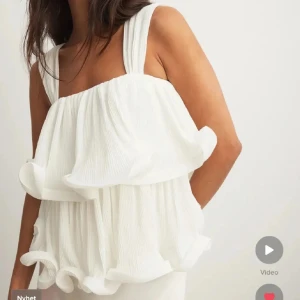 Vit plisserad blus från  Lojsan Wallin x NA-KD - Superfin vit blus från NA-KD med breda axelband och volanger 