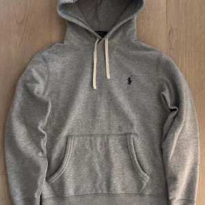 Grå Ralph Lauren Hoodie - Fet Ralph Lauren hoodie i extremt bra skick, endast använd ett fåtal gånger.  Inköpt från deras hemsida i höstas, nypris runt 1500kr. Prutmån finns, hör även av er om mått eller annat! Riktigt skön. 