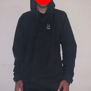Svart vindjacka från Haglöfs - Säljer en svart vindjacka från Haglöfs i storlek M. Jackan har lång ärm, hög krage och dragkedja framtill. Perfekt för utomhusaktiviteter och enkel att bära med sig. Klassisk och stilren design med Haglöfs-logga på bröstet.