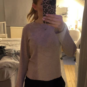 Beige/rosa  stickad tröja från Vero Moda - Mysig beige stickad tröja från Vero Moda. Klassisk rund halsringning och långa ärmar. Perfekt för lager-på-lager och enkel att matcha med olika outfits.