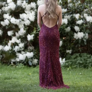 Vinröd glittrig långklänning med smala axelband - Säljer en vinröd långklänning med glittriga detaljer och smala axelband. Klänningen har v-ringning och öppen rygg, perfekt för bal eller fest. Sitter tight och har en elegant siluett. Uppsydd till mig som är 160. 