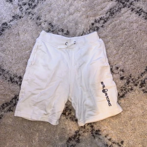 Vita shorts från Sail Racing med tryck - Vita shorts från Sail Racing med snörning i midjan och tryckt logga på ena benet. Mjukt material och fickor både fram och bak. Perfekta för sommaren. Mycket fräscha och inga defekter!