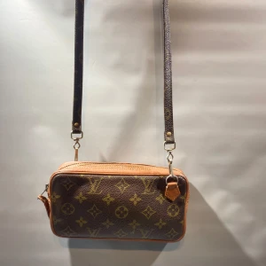 Louis Vuitton Pochette  - Hej! Säljer nu min Louis Vuitton marly bandouliere pochette. Vintage skick, givetvis äkta. Hör gärna av er för fler bilder eller om ni har frågor kring väskan.