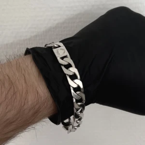 Hugo Boss Äkta 925 Silver Armband - Armband i äkta massivt 925 silver av Hugo Boss, denna modell tillverkas inte längre och är svårt att få tag på! 22 cm lång och 10mm bred, väger 43.9g! Unikt lås och lätt att korta ned om det behövs.