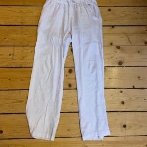 Vita linnebyxor  - Säljer ett par vita linnebyxor från 157  med resår i midjan och raka ben. Byxorna har en avslappnad passform och en bakficka. Perfekta för varma dagar eller en chill stil.