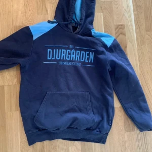 Djurgården hoodie - Mörkblå hoodie med ljusblå detaljer och tryck på bröstet. Perfekt för dig som hejar på Djurgården! Använd få gånger, passar st S-M. Skicka om du vill ha mer bilder, mått osv!