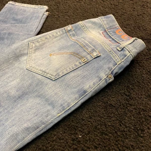 Dondup jeans W32 Geroge  - Säljet ett par feta dondup George, Skick: 9/10, Pris:699, Modell:Geroge, Storlek: W32 ,Det är slitningar på framsidan som det ska va på denna modell, vid frågor och funderingar är de bara och höra av sig ⚜️ Frakt 1-3 arbetsdagar 🚚
