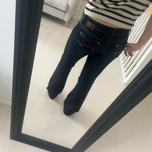 Mörkblå bootcut jeans från Mavi bella jeans  - Säljer ett par mörkblå jeans från mavi jeans med bootcut-passform. Jeansen har klassiska fickor bak och fram, kontrastsömmar och läderpatch med logga bak i midjan. Perfekta för dig som gillar en tidlös jeansstil.