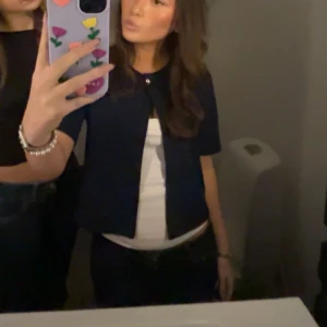 Mörkblå kortärmad kofta - Säljer en mörkblå kortärmad kofta med rund halsringning och knappar framtill. Perfekt att ha över en topp eller t-shirt. Enkel och stilren design som passar till mycket. Från Gina tricot och är knappt använd❤️