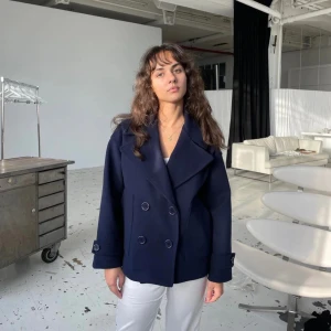 Design by si kappa - Trendig marinblå kappa från design by si i storlek XS/S. I fint skick och nypris är 757kr. (Första bilden är från hemsidan)