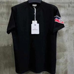 Svart t-shirt från Moncler med logga tre färgad tripes - Svart t-shirt från Moncler med rund halsringning och korta ärmar. På ena ärmen finns ett broderat Moncler-märke samt röd, vit och blå randig detalj. Klassisk och stilren design med exklusiv känsla. Pris kan diskuteras! 