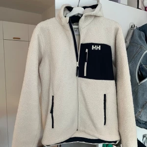 Helly Hansen teddyjacka!  - Jättefin jacka, använd fåtal gånger. Det var en fläck på baksidan när jag fick hem den ny, men jackan har nyss tvättats och det försvann nästan helt, se bild 2🌸storlek 176 cm/16 år. Nypris 999 kr