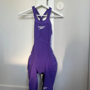 Lila speedo baddräkt - Tävlingsbaddräkt Speedo Fastskin LZR Pure Valor Open Back. Baddräkten är i storlek 26 (se bild). Baddräkten är använd och har lossat i limningen på ett ställe, men går nog lätt att limma ihop. I övrigt är den i bra skick. Nypris är cirka 4000 kronor. Säljes för 1000 kronor. Köparen står för porto.