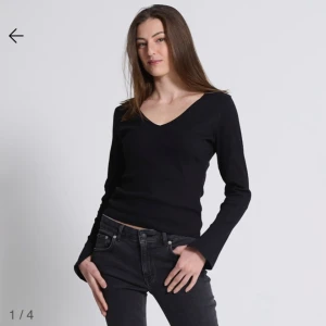 Svart ribbad v-ringad tröja - Säljer en svart långärmad tröja med v-ringning och ribbad struktur. Tröjan har en tight passform och är perfekt för lager-på-lager eller som den är. Enkel och stilren design som passar till det mesta.