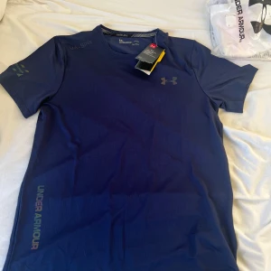 Under armour t shirt - Aldrig använd t shirt från undrr armour perfekt för gym eller liknande storlek L men men sitter som en liten M