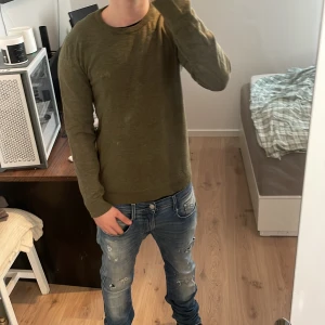 Olivgrön långärmad tröja - Säljer en enkel och stilren olivgrön långärmad tröja med rund halsringning. Perfekt att matcha med jeans eller andra byxor för en avslappnad look.