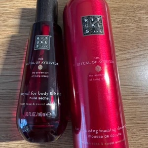 Rituals The Ritual of Ayurveda body oil och duschmousse - Säljer ett set från Rituals The Ritual of Ayurveda med en torr olja för kropp och hår (100 ml) samt en harmonising foaming shower gel (200 ml). Båda har doft av indisk ros och sötmandel. Flaskorna är röda med svarta och silvriga detaljer. Nytt och oanvänd