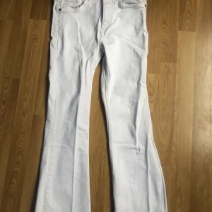 Vita jeansbyxor från Zara - Vita jeans från Zara, modellens namn är okänt men de är lite ”flare” längst nere, även lite trådig look där. Skulle passa någon som är 155-160cm, de är designade för att inte vara helt över skorna när man använder dem🩷De är ganska skrynkliga pga att de ej används på länge & har varit vikta, tvättas såklart alltid innan det säljs! Originalpris ca 380kr 