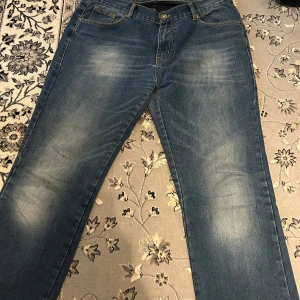 Blå jeans från Sam's - Snygga blå jeans från Sam's med klassisk femficksdesign och gul söm. De har en bekväm passform och är perfekta för en avslappnad stil. Midjan är märkt XL/32 och de har en knappgylf. Säljs pågrund av att dem blivit för stora på mig. Priset kan diskuteras!