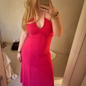 Rosa klänning med v-ringning - Säljer en snygg rosa klänning med v-ringning och halterneck. Klänningen har en figurnära passform och är perfekt för sommarens varma dagar. 