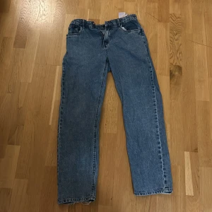 Blå jeans från LMTD - Säljer ett par klassiska blå jeans från LMTD. De har en rak passform med dragkedja och knapp framtill. Perfekta för en avslappnad stil.