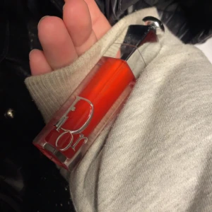 Rött läppglans från Dior - Snyggt rött läppglans från Dior med elegant förpackning och silverdetaljer. Perfekt för att ge en glansig och färgstark look.den ser inte så röd ut på läpparna, den blir mer åt de rosa hållet 