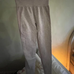 Gymshark byxor - Snygga lila leggings med hög midja och en tight passform. Perfekta för träning eller en avslappnad dag. Materialet är stretchigt och bekvämt, vilket ger en smickrande silhuett.