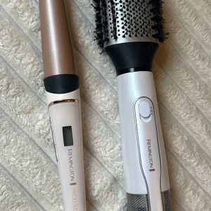 Remington Proluxe locktång och varmluftsborste - Säljer en Remington Proluxe locktång och en varmluftsborste. Locktången har en digital display och en elegant design i vitt och guld. Varmluftsborsten har en rund borste med ventilationshål för effektiv styling. Perfekt för att skapa volym och lockar.